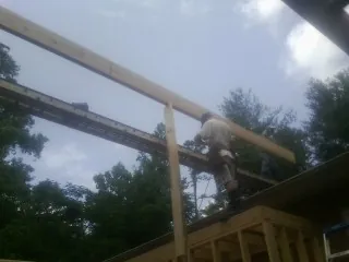 Carpenter setting a ridge beam over a new addition frame — Ice Dam Removal by Roofing Brothers in Hodgenville