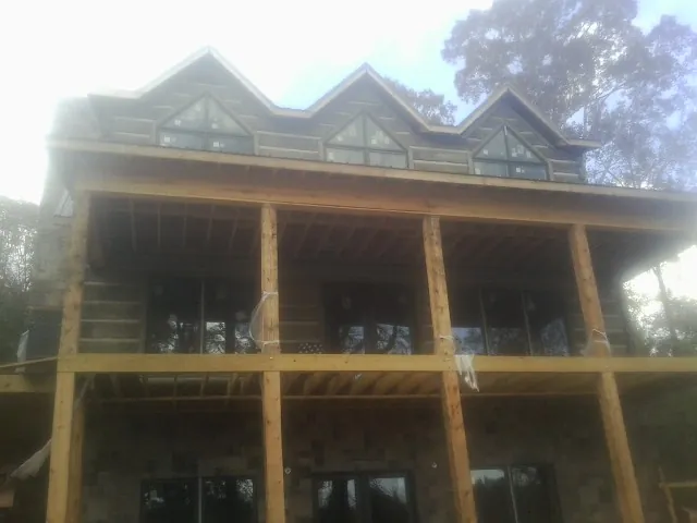 Dormers and porch framing on a large log home under construction — Roof Coating work by our crew in Hodgenville
