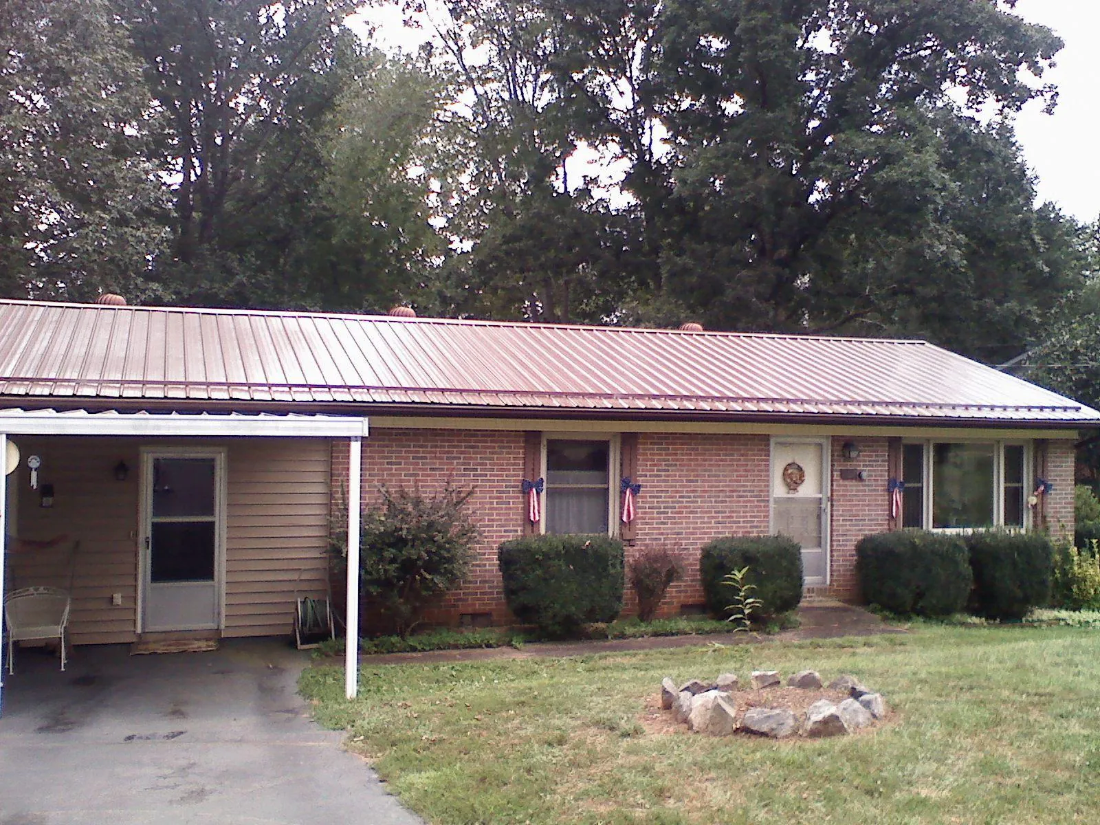 Bronze metal roof and carport on a brick ranch home — Roof Repair work by our crew in Hodgenville